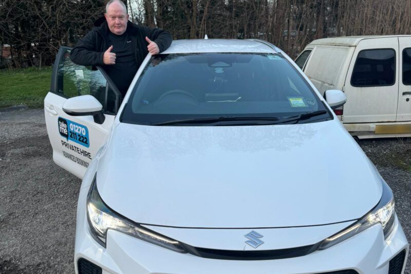 Veteran taxi driver stood next to his Suzuki Swace proudly