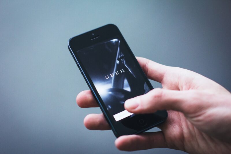 a hand holding a smart phone with the uber app opening