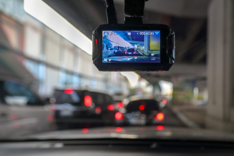 Dash camera in car with view of traffic through the window